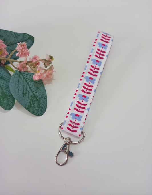 Our fabric wristlet in a white fabric with retro floral pattern with sewn in silver keyfob. 