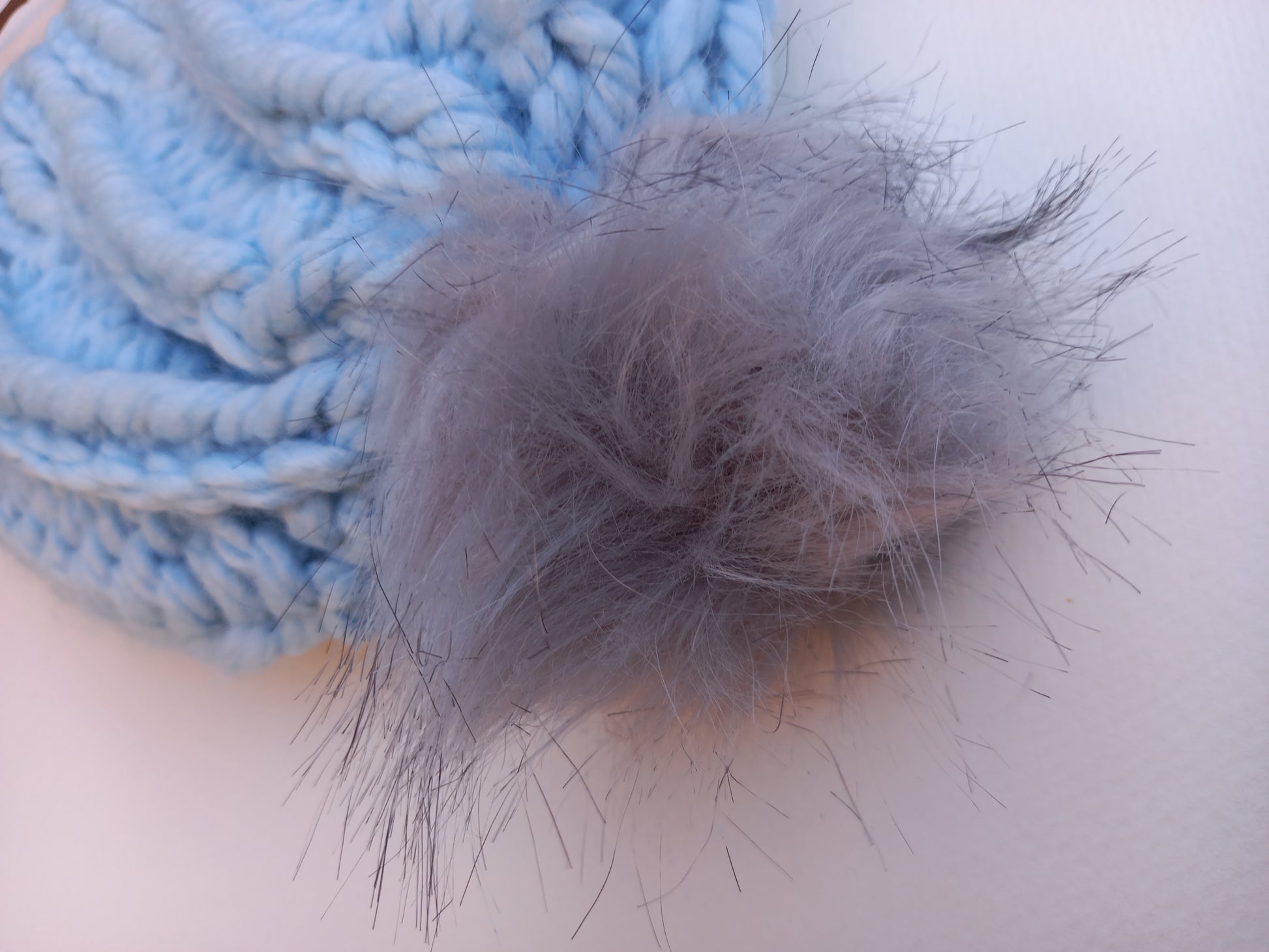 This is a close up of the light grey fluffy pompom.